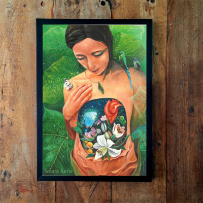 Quadro emoldurado com pintura de uma mulher de perfil segurando uma folha de bananeira, com o peito aberto revelando tucanos e flores, sobre fundo verde.